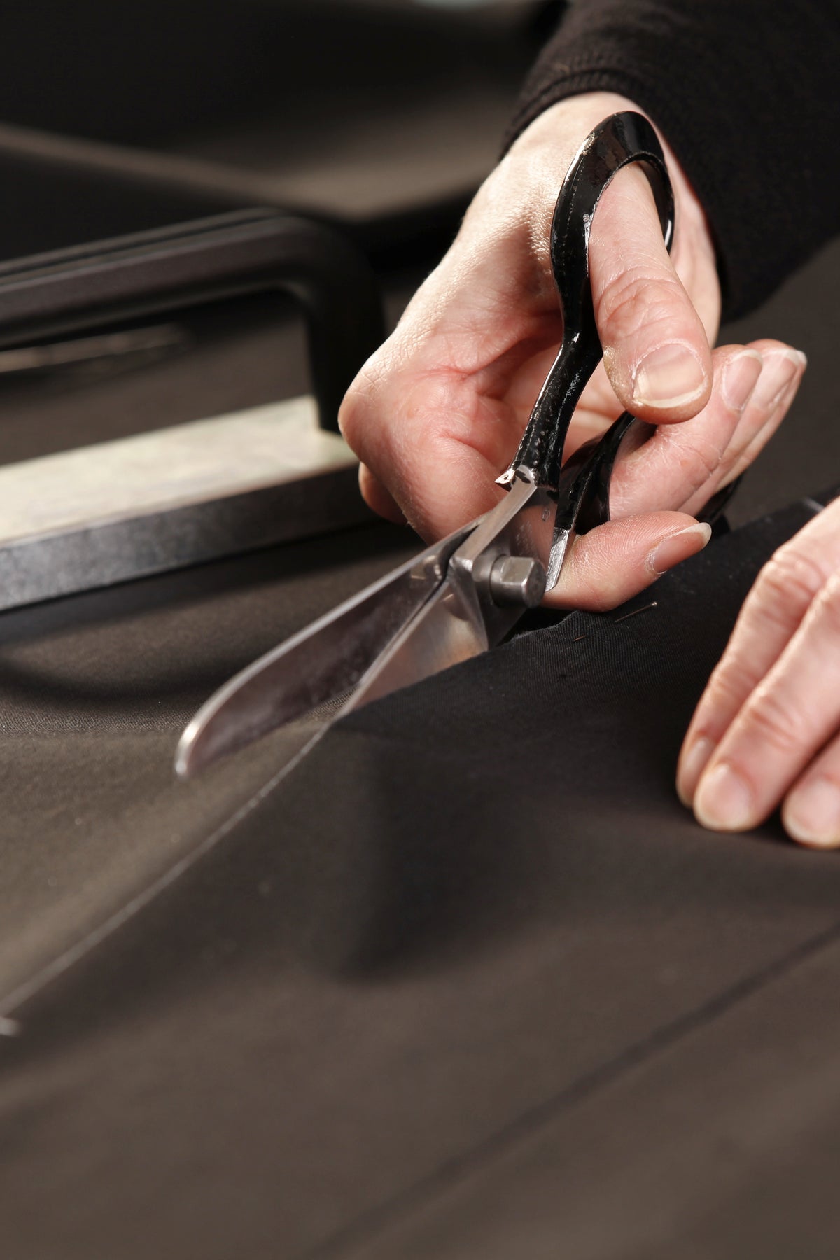 Handarbeit im Atelier: Zuschnitt des Robenstoffs mit der Schere