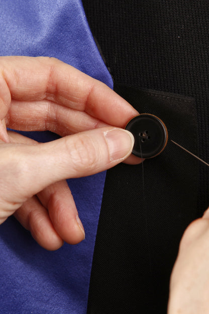 Handarbeit im Atelier: ein Knopf wird von Hand angenäht
