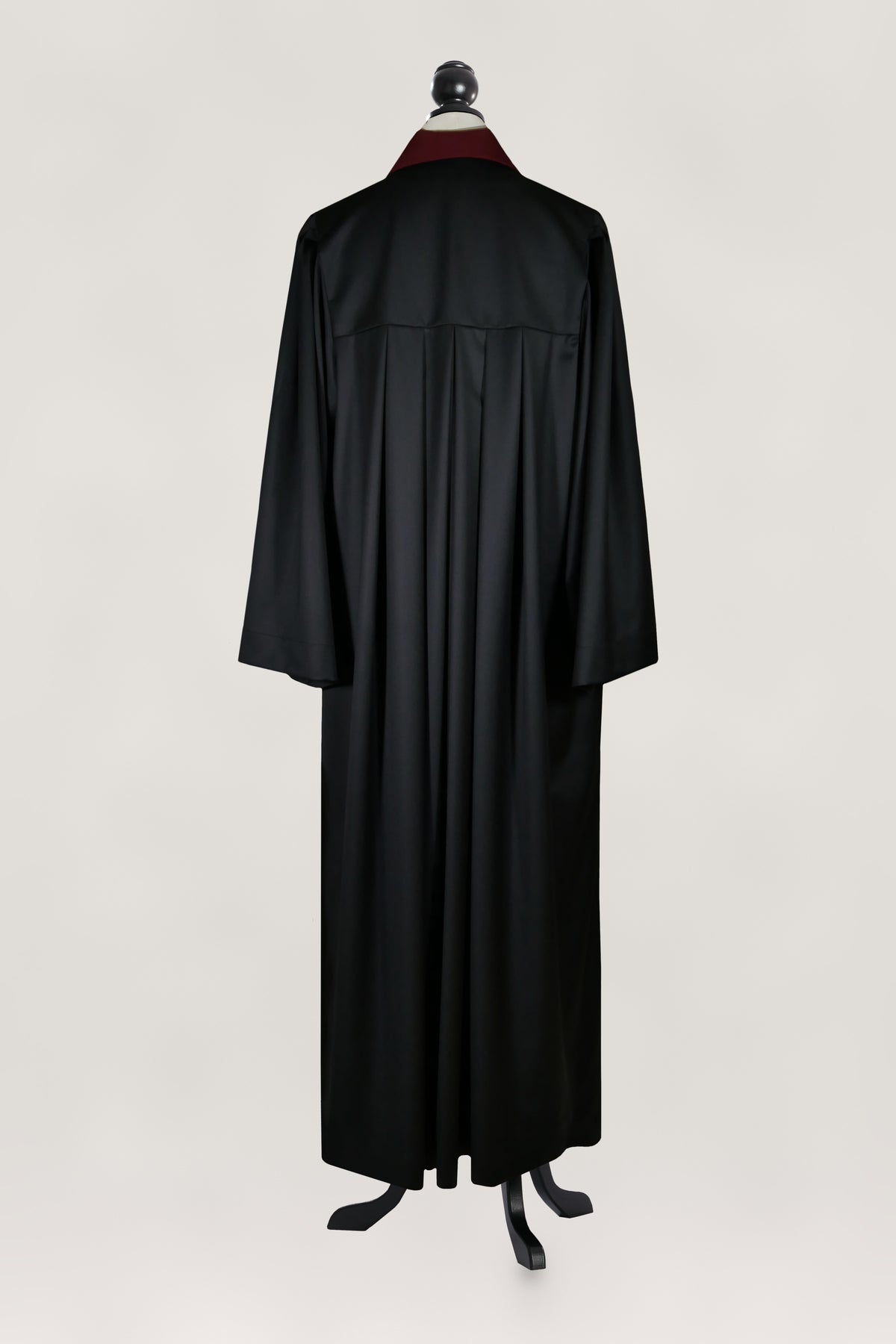 Talar Rückenansicht: schwarze Robe mit weinrotem Stehkragen, Faltenrücken, weiten Ärmeln, bodenlang